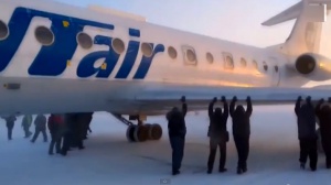 Пътници бутат самолет, за да размразят спирачките му (видео)