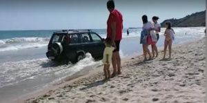 ВИДЕО Пиян директор на училище подкара джипа си между кърпите на плажа в Кранево и цопна в морето