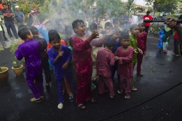 Млади мюсюлманчета пръскани с вода по време на церемония за масово обрязване в Малайзия.