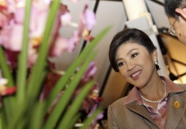 Премиерът на Тайланд Инглук Шинаватра разглежда орхидея, кръстена на нея в нейна чест, по време на посещението си в Сингапур.