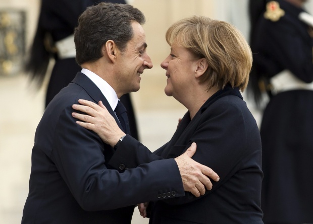 Френският президент Никола Саркози поздравява германския канцлер Ангела Меркел при пристигането й в Елисейския дворец за срещата им по повод кризата в еврозоната, 5 декември.