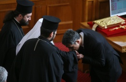 Новият президент на Република България Росен Плевнелиев целува ръката на главата на Българската православна църква патриарх Максим по време на церемонията по заклеването си.