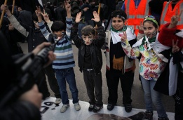 Деца се преструват, че са заплашени от въоръжен мъж по време на протест срещу действащия режим в Сирия пред сградата на Арабската лига в Кайро, Египет.