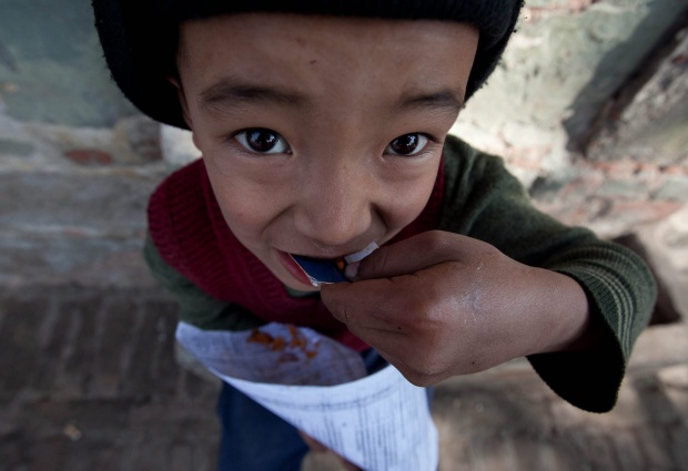 Непалско дете яде храна, закупена от улична количка в столицата Катманду.