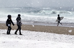 Дори мразовитото време и снегът не спират сърф ентусиастите в Сан Себастиян, Испания.