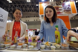 Момичета презентират чили сос и лют червен пипер в мексиканския павилион по време на 37-ото международно изложение на храните в Япония.
