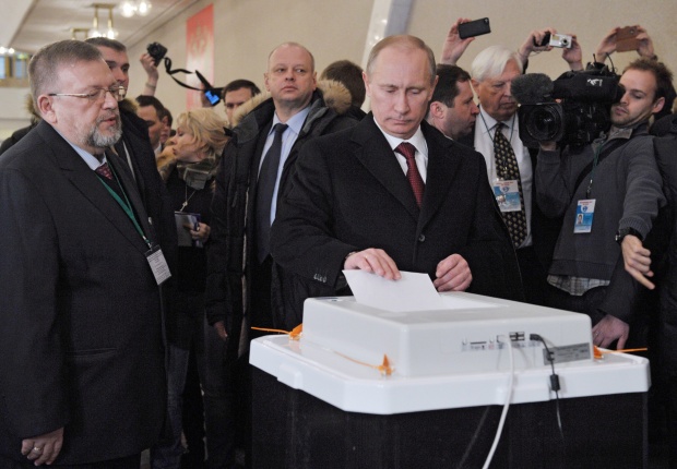 Настоящият премиер на Русия Владимир Путин, който е и най-вероятният бъдещ президент на страната, пуска своята бюлетина на изборите в неделя.