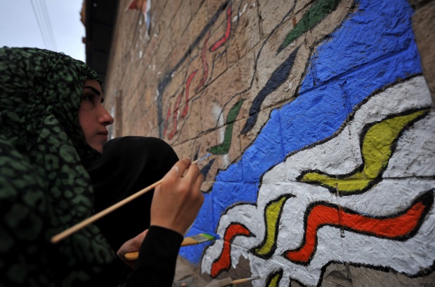 Девойка рисува графит на улица в Йемен, където въоръжени сили на дисиденти се сблъскаха с армията, лоялна на президента Али Абдула Салех.