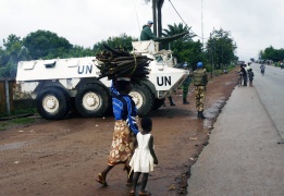 Бежанци минават покрай патрул на ООН в Кот д'Ивоар, след като току-що са избягали от атака на местни ловци, наречени „Дозо“.