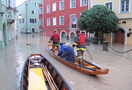 Службите за аварии плават на лодка по наводнените улици на Шердинг, Австрия, за да спасят отцепени граждани
