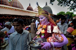 Индийски хинду месия носи поднос за дарения, като минава през хилядите на фестивала Амбубачи в Гуахати, Индия