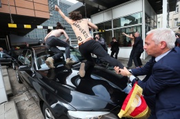 Активистка от "Фемен" скача върху колата на премиера на Тунис Али Лайаред, докато той напуска еврокомисията в Брюксел