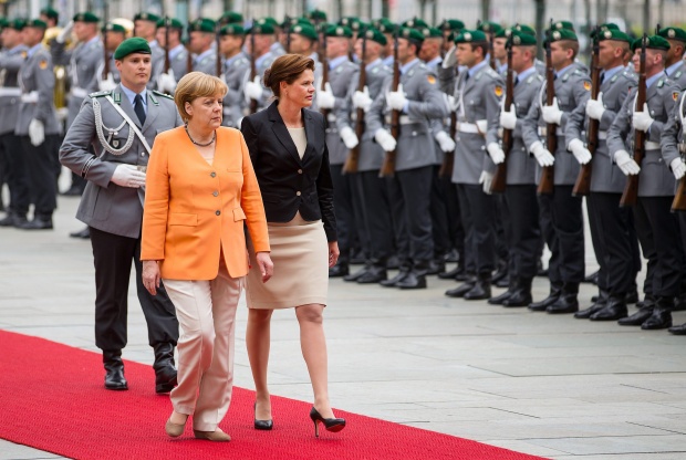 Канцлерът Ангела Меркел придружава словенският премиер Аленка Братушек, докато им отдават военна чест в Берлин