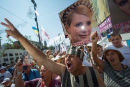 Протестиращи на бившия украински премиер Юлия Тимошенко държат плакати на демонстрация в Киев по повод две години, откакто тя е в затвора