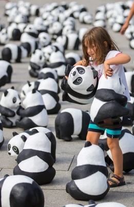 Малката Матилда си играе с една от 1600 фигури панда, разпръснати на ж.п. гара в Берлин от световната природозащитна организация WWF, която иска да напомни колко е реалният брой на пандите по света