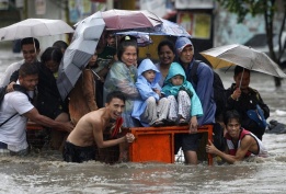 Филипинци се опитват да се спасят от наводнена улица в Las Pinas City, южно от Манила