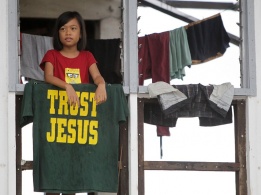 Филипинче стои на терасата на опустошения си дом след тайфуна „Хайян“