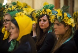 Млади неомъжени жени носят шапки в жълто и зелено, направени от приятелка, както повелява традицията на Св. Катерина в Париж, Франция