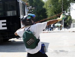 Протестиращ срещу правителството на Тайланд обстрелва сградата с камъни в акция за сваляне на кабинета