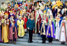 Меркел дойде на патерици в канцлерството в Берлин, за да види дечица, изпълняващи коледни песни и попя с тях на Богоявление, когато католици и протестанти честват Празника на тримата влъхви