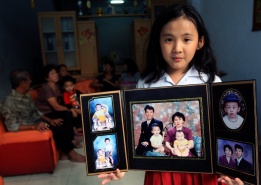 Айу Сулиасти - дъщеря на изчезнали в полет MH370 родители, показва техни снимки в дома си в Медан, Индонезия