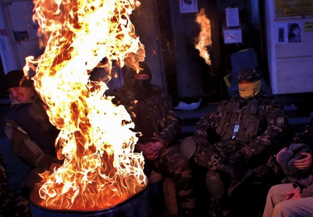 Украински ветерани от движението "Евро-майдан" се топлят на огън на емблематичния площад "Независимост" в Киев