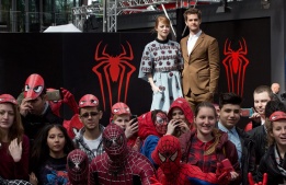 Актьорите Ема Стоун и Андрю Гарфийлд позират пред тълпа маскирани фенове на премиерата на "Невероятният Спайдърмен" в Берлин, Германия