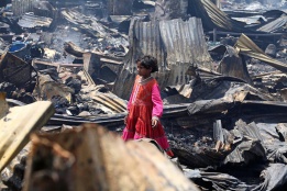 Малко момиче стои сред останките от огромен пожар в Индия, който опожари около 500 къщи в Ню Делхи