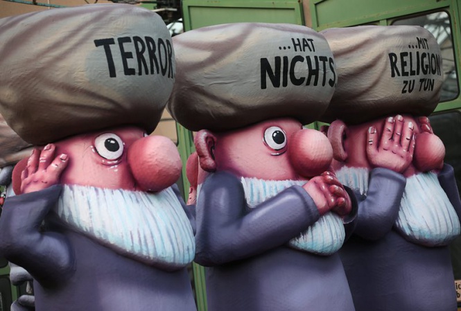 Три фигури, на чиито шапки пише "Терорът няма общо с религията", са част от карнавално шествие в Дюселдорф, Германия