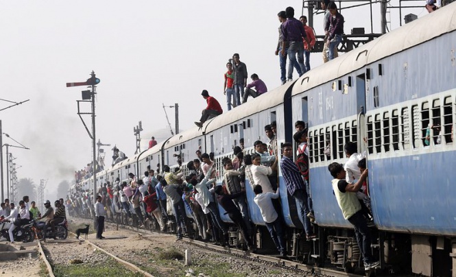 Индийски пътници висят на препълнен влак