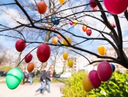 Минувачи се радват на окачени разноцветни яйца по дърветата в Хамбург, Германия