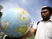 Демонстрант държи глобус по случай Световния ден на Земята в Суматра, Индонезия