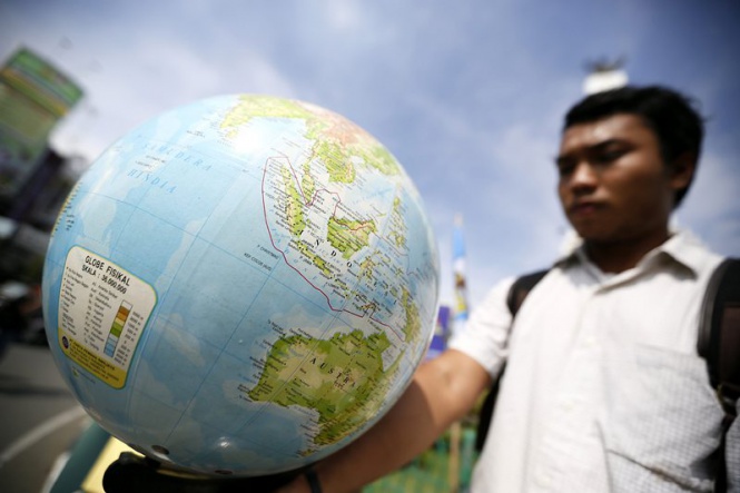 Демонстрант държи глобус по случай Световния ден на Земята в Суматра, Индонезия