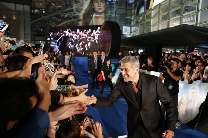 Актьорът Джордж Клуни приветства феновете си на премиерата на филма "Утреландия" в Шанхай, Китай